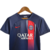 Camisa do kit infantil do Paris Saint Germain I Nike 23/24 na cor azul, com detalhes em vermelho e logo do clube.