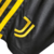 Detalhe do logo da Juventus em um kit infantil preto e amarelo da Adidas.