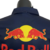 Detalhe da parte de trás da camisa masculina da Red Bull 23/24 de Fórmula 1, com o logotipo da equipe em destaque.