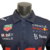 Camisa masculina azul da Red Bull para a temporada de Fórmula 1 23/24, com logos de patrocinadores.