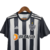 Camisa do Kit Infantil Atlético Mineiro I 23/24, preta e branca, com detalhes da marca Adidas e logo do time.