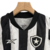 Detalhe da camiseta do kit infantil Botafogo I 23/24 da Reebok, destacando as cores preto e branco e o escudo do time.