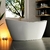 Banheira freestanding Atenas branca em um ambiente moderno com decoração aconchegante.