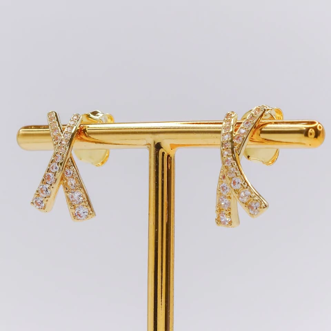 Brinco X assimétrico cravejado com micro zircônias banhado a ouro 18K