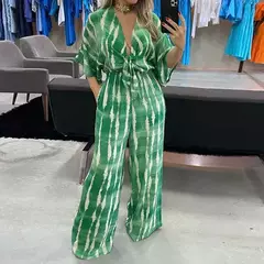 Macacão feminino Pamela em verde com estampa listrada, usando uma modelo em ambiente de loja.