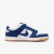 Tênis Nike SB Dunk Low nas cores azul e branco com detalhes em camurça e sola de borracha.