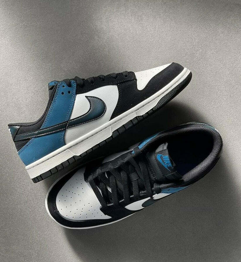 Tênis Nike SB Dunk Low "Industrial Blue" em azul, preto e branco, com detalhes em couro e sola preta. Vista lateral e de cima do calçado.