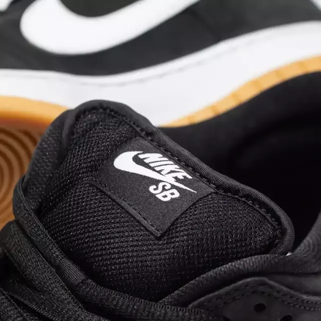 Tênis Nike SB Dunk Low "ISO Black Gum" na cor preta, destacando o logo Nike SB na lingueta.