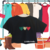 Cropped preto com estampa de três corações coloridos em verde, vermelho e estampado, pendurado em um cabide.