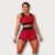 Modelo usando conjunto fitness vermelho com top e short duplo, destacando a malha e o design moderno.