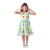 Menina vestindo um vestido infantil colorido com estampa de flores e formas, fazendo uma expressão divertida.