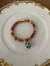 Pulseira de fio indiano laranja com dourado e bola azul turquesa, fecho de ima.