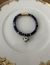 Pulseira de fio indiano azul marinho, verde e vermelho com bola azul turquesa, fecho de imã.