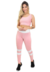 Modelo usando conjunto fitness rosa e branco, composto por calça legging e cropped, ideal para atividades físicas.