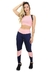 Modelo vestindo conjunto fitness composto por calça legging azul com detalhes em rosa e cropped rosa com detalhe azul.