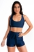 Modelo usando um conjunto fitness cropped e short liso na cor azul marinho.