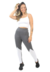 Modelo usando um conjunto fitness cropped branco e legging mescla com detalhes em branco, posando com um sorriso.