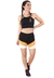 Mulher usando conjunto fitness cropped preto e shorts com faixas em preto, branco e amarelo, posando de pé.