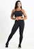 Modelo usando conjunto fitness preto composto por calça legging e top com detalhe em transparência.