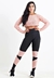 Modelo usando conjunto fitness com calça legging preta e detalhes em rosa, e top rosa cropped.