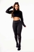 Mulher usando conjunto fitness preto com calça legging e cropped de manga longa em tela dry.