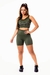 Modelo usando conjunto fitness feminino verde militar, composto por short de cintura alta e cropped regata com detalhes em vivo branco.