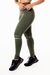 Calça legging fitness verde militar com detalhes em branco e cintura alta, usada por uma modelo com tênis escuros.