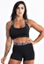 Modelo usando conjunto fitness preto composto por cropped e short elástico.