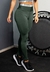 Calça legging verde com elástico na cintura alta, ideal para moda fitness, usada em ambiente de treino.