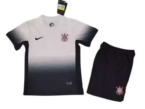 Conjunto infantil do Corinthians, composto por camiseta branca degradê e short preto.