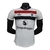 Camisa branca do Manchester United III 24/25 com detalhes em vermelho e preto, fabricada pela Adidas para jogadores masculinos.