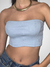 Blusa cropped azul claro, sem mangas, modelando o corpo da modelo.