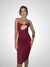 Modelo usando um vestido mídi swing de cor vinho com decote em forma de gota.