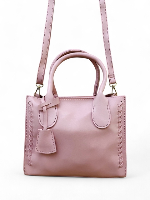 Bolsa feminina tiracolo média na cor rosa, com alças curtas e longa, detalhes em costura lateral e um pequeno pendente.
