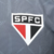 Camisa pré-jogo do São Paulo FC, modelo 25/26, masculina, cinza com detalhes em vermelho e branco, da marca New Balance.