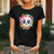 Camiseta preta com estampa de caveira kawaii rodeada por flores coloridas e um laço rosa.