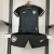 Conjunto infantil Botafogo II da Reebok, composto por camisa preta com detalhes dourados e short preto, exibido em um cabide.