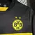 Camisa preta e amarela do Borussia Dortmund II, modelo away 24/25 da Puma, com logotipo do time e patrocínio em destaque.