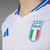 Camisa branca da seleção italiana de futebol, modelo away 2024/25, com detalhes em verde e vermelho e logo da Adidas.