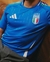 Camisa azul da seleção italiana de futebol, modelo 2024/25, fabricada pela Adidas, com detalhes em verde e branco.