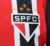 Detalhe do logo do São Paulo FC na camisa regata vermelha e preta