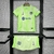 Kit infantil do Barcelona III 24/25 da Nike na cor verde, composto por camisa e short, exibido em um suporte.