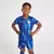 Kit infantil azul do Chelsea I Home 24/25 da Nike, composto por camiseta e short com detalhes em azul e logotipo do time.