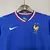 Kit infantil da seleção da França com camisa azul e calças brancas, estampado com o logo da Nike e o emblema da seleção.