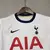 Kit infantil do Tottenham Hotspur para a temporada 24/25, composto por camisa branca e calção azul.