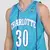 Homem usando a regata NBA Charlotte Hornets Curry N° 30 da Mitchell & Ness, na cor azul.