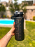 Botella motivacional de color negro, con capacidad de 2000 ml. Cuenta con tapa plástica con traba, bombilla, medidor de agua y frases motivadoras para mantenerte hidratado.