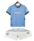 Uniforme infantil do Manchester City 24/25, contendo camisa azul e shorts brancos.