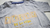 Remera gris con braille salmón en internet