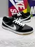 Tênis Nike SB Dunk Low Pro nas cores preto, grafite e branco, com detalhes em couro e sola de borracha.